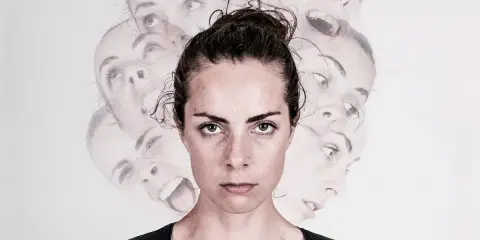 Kobieta z wieloma twarzami wyrażającymi różne emocje, na jasnym tle.