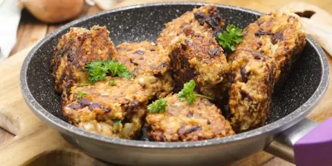 Herzhafte vegetarische Frikadellen mit Kidneybohnen, frisch in der Pfanne gebraten und mit Petersilie garniert.