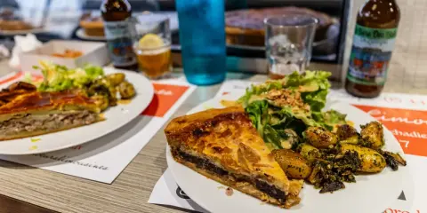 Tranche de pâté en croûte, spécialité Limoges, servie avec salade et pommes de terre rôties.