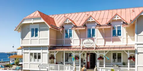 Välkommen till Strandvillan i Lysekil, ett charmigt hus vid havet med röda tak och vita detaljer.