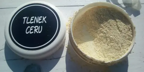 Otwarty pojemnik z jasnym proszkiem, na wieczku napis "TLENEK CERU".
