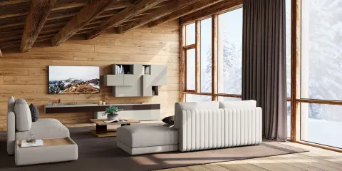 Accogliente soggiorno con travi in legno a vista, mobili chiari e vista innevata. I colori delle case di campagna si riflettono nell'arredo.
