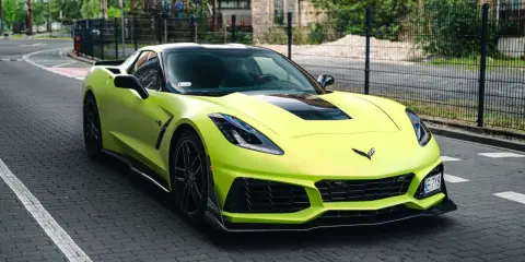 Jasnozielony Chevrolet Corvette C7 na brukowanej drodze. Zastanawiasz się nad corvette c7 cena?