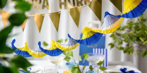 Festlig student dekoration inspiration med girlanger i guld och blått/gult. Perfekt för att fira!