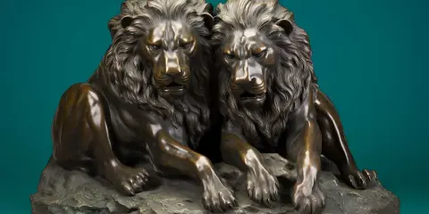 Deux lions en bronze majestueux, posés sur un rocher. Une œuvre qui montre comment faire briller du bronze pour un rendu saisissant.