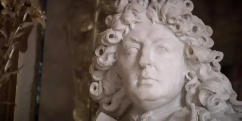 Marmorstatue eines Mannes mit Lockenperücke, die an die Pracht des Absolutismus erinnert.