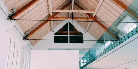 Techo interior con vigas de madera y un moderno **aislante térmico para techos interiores** que complementa la arquitectura.