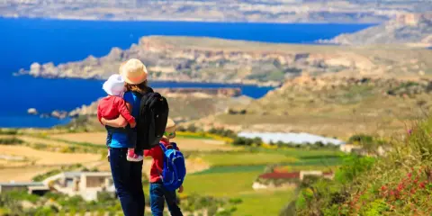 Madre con bambini ammira il panorama di Malta. Un'avventura indimenticabile per tutta la famiglia.