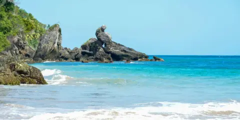 Idealne miejsce, gdzie na urlop w marcu: tropikalna plaża z turkusową wodą, skalistymi formacjami i bujną zielenią.