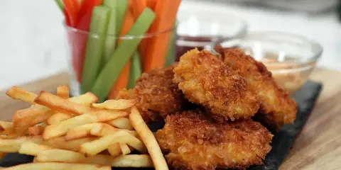 Krispiga chicken nuggets med pommes frites och grönsaksstavar. Perfekt för en mysig kväll!