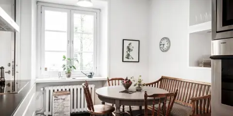 Mysig köksvrå med runt matbord, träbänk och stolar. Perfekt för runt matbord inspiration.