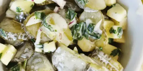 Pyszna surówka z ogórka kiszonego z ziemniakami i cebulką, polana kremowym sosem. Idealna na letni obiad.