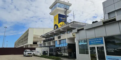 Kontrolltorn och terminalbyggnad vid Zanzibar flygplats. En vit SUV parkerad framför.