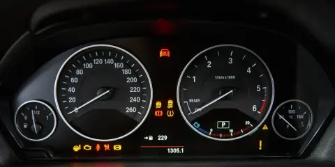 Cruscotto auto con tachimetro, contagiri e spie accese, tra cui il simbolo pressione gomme.