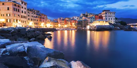 Case colorate illuminate sul mare calmo, la **riviera ligure di levante** incanta al crepuscolo.