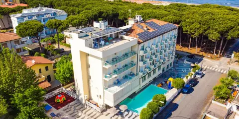 Hotel Primula Azzurra, con piscina, area giochi e vista mare, immerso nel verde di una pineta.