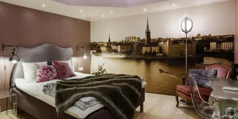 Ett mysigt rum med en stor säng och en fototapet av Stockholm. Perfekt för ditt vandrarhem i Sigtuna.