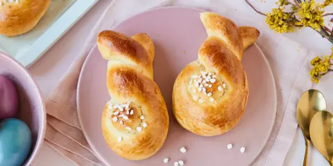 Zwei goldbraune Hefehasen mit Zuckerkristallen, bereit zum Osterfrühstück. Das Backen von Hefehasen ist eine schöne Tradition.