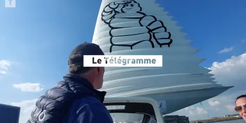 Un homme regarde une voile géante ornée du logo Michelin. Le Télégramme est affiché sur la voile.