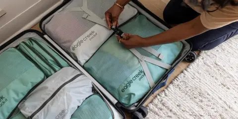 Frau packt ihren Koffer mit Packwürfeln. So packe ich meinen Koffer für die Reise, ordentlich und platzsparend.