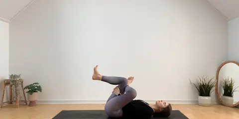 Frau in Yoga-Pose auf Matte, entspannt während ihrer Yoga-Periode.