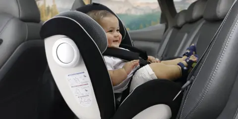 Bebé sonriente en silla de coche, grupo 0 hasta 18kg. Viaje seguro para los más pequeños.