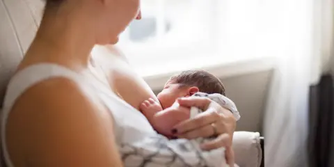 Matka karmi piersią dziecko, zastanawiając się, czy ibuprofen jest bezpieczny.