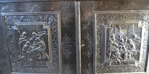 Détail d'un meuble Louis XIII sculpté de scènes bibliques et de motifs floraux.