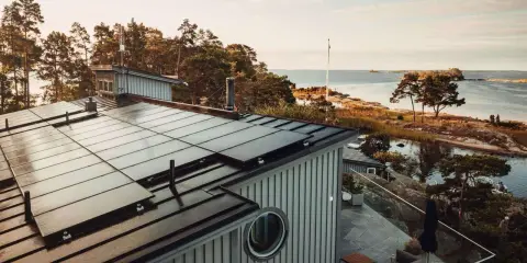 Tak med solpaneler vid vattnet, en vy som en solkartan Stockholm.