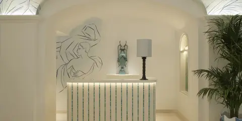 L'entrée art déco dévoile une réception lumineuse, ornée de fresques murales et d'une plante luxuriante.