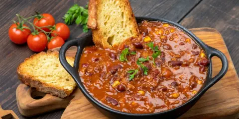 Rozgrzewające chili con carne z fasolą i kukurydzą, podane z chrupiącą grzanką. Idealne danie, co można zjeść na obiad.