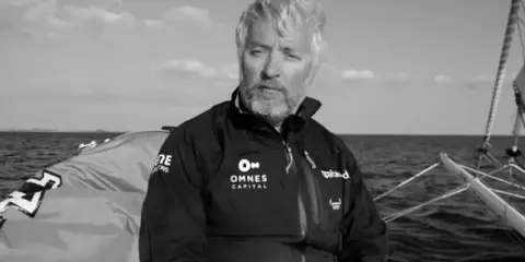 Le navigateur Yvan Bourgnon, le regard déterminé, sur son bateau en pleine mer.