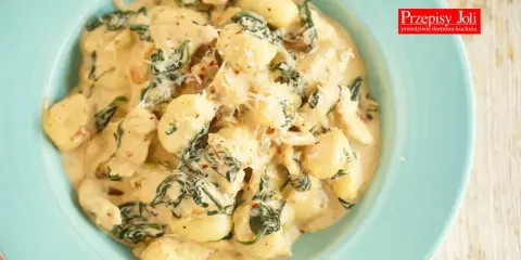 Pyszne gnocchi z kurczakiem i szpinakiem w kremowym sosie, posypane parmezanem. Idealne danie na szybki obiad.