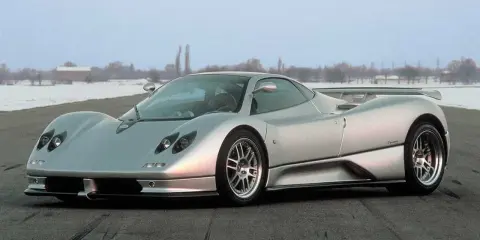 Silberner Pagani Zonda C12 steht auf einer Straße, im Hintergrund verschneite Bäume und Gebäude.