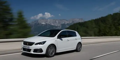 Blanco Peugeot 308 con motor 1.5 BlueHDi 100cv en carretera, con montañas al fondo. ¿Problemas?