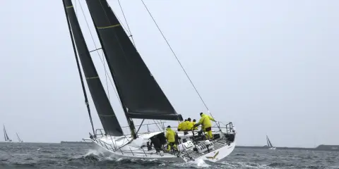 Segelboot mit gelber Crew bei einem spannenden ocean race.