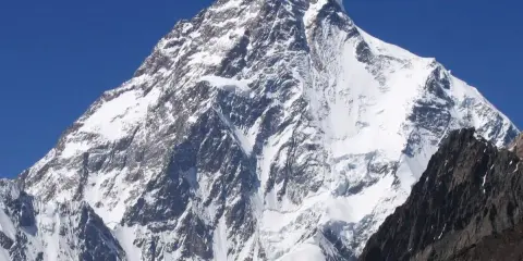 K2, najwyższy szczyt Karakorum, majestatycznie wznosi się na tle błękitnego nieba.