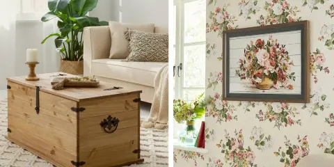 Un accogliente soggiorno in stile cottage core con un baule in legno, un divano beige e carta da parati floreale.