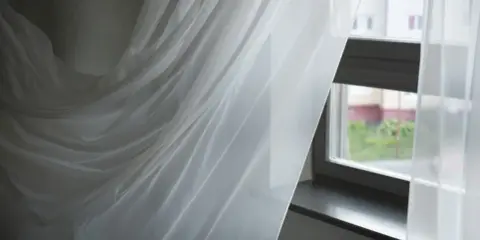 Delikatne, białe firanki falujące przy oknie. Zastanawiasz się, jak wybielić firanki, by znów lśniły czystością?