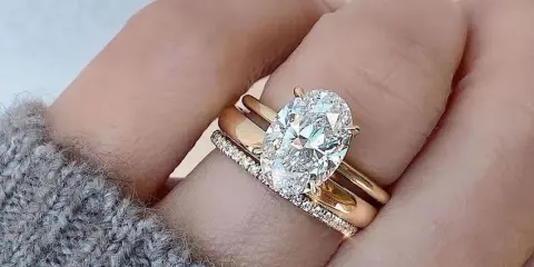 Un solitario anello con diamante ovale, simbolo di un amore eterno e prezioso, adorna un dito.