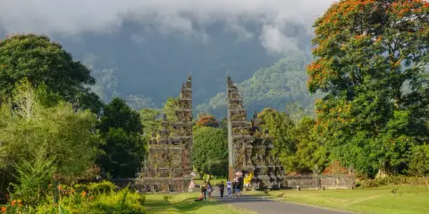 Brama na Bali, jakby z innego świata, wita podróżnych. W tle góry i chmury.