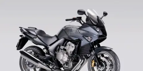 Szary motocykl Honda CBF 600, zgrabny i sportowy, idealny dla osób szukających komfortu i odpowiedniej wysokości siedzenia.