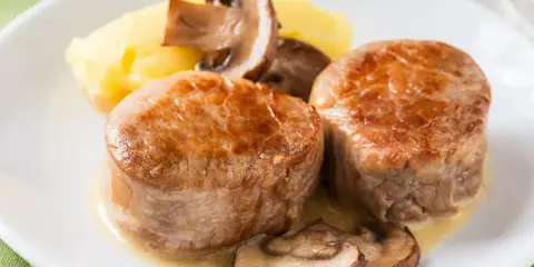 Dwa medaliony z polędwicy wieprzowej z pieczarkami i puree ziemniaczanym. Idealny polędwica wieprzowa przepis na obiad.