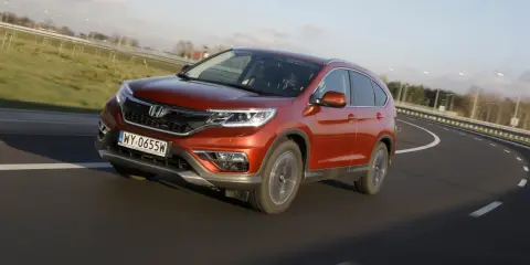 Pomarańczowy Honda CR-V 1.6 diesel na zakręcie drogi. Czy to początek honda cr-v 1.6 diesel usterki?
