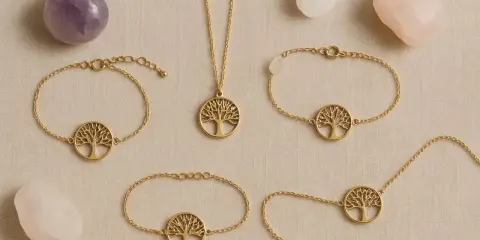 Gioielli con albero della vita in oro, circondati da pietre di quarzo. Il quarzo pietra significato è legato alla crescita e alla protezione.