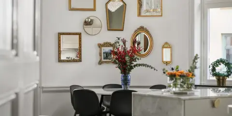 En samling antika speglar ramar in matbordet och skapar en elegant atmosfär.
