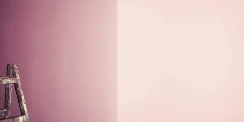 Alte Leiter steht vor einer Wand, die in zwei Rosatöne geteilt ist. Ein Projekt zum **Wandfarbe mischen**?