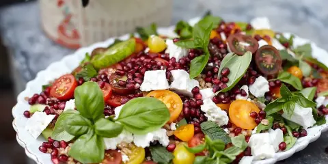 En färgsprakande sallad med granatäpple, tomat, fetaost och basilika. Ett perfekt kålmaja recept för sommaren.
