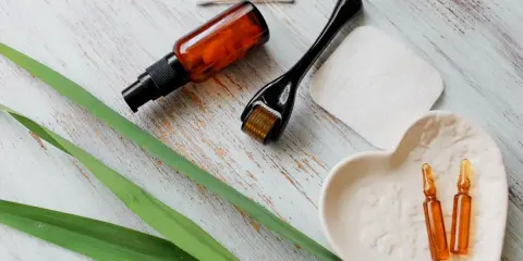 Zestaw do pielęgnacji: serum z **retinolem**, roller, ampułki i waciki.