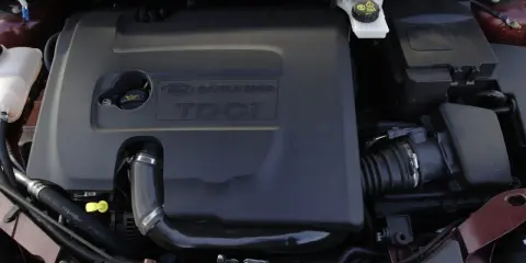Silnik Ford Focus MK2 1.6 TDCI. Widoczna czarna osłona silnika z napisem "DURATORQ TDCI".